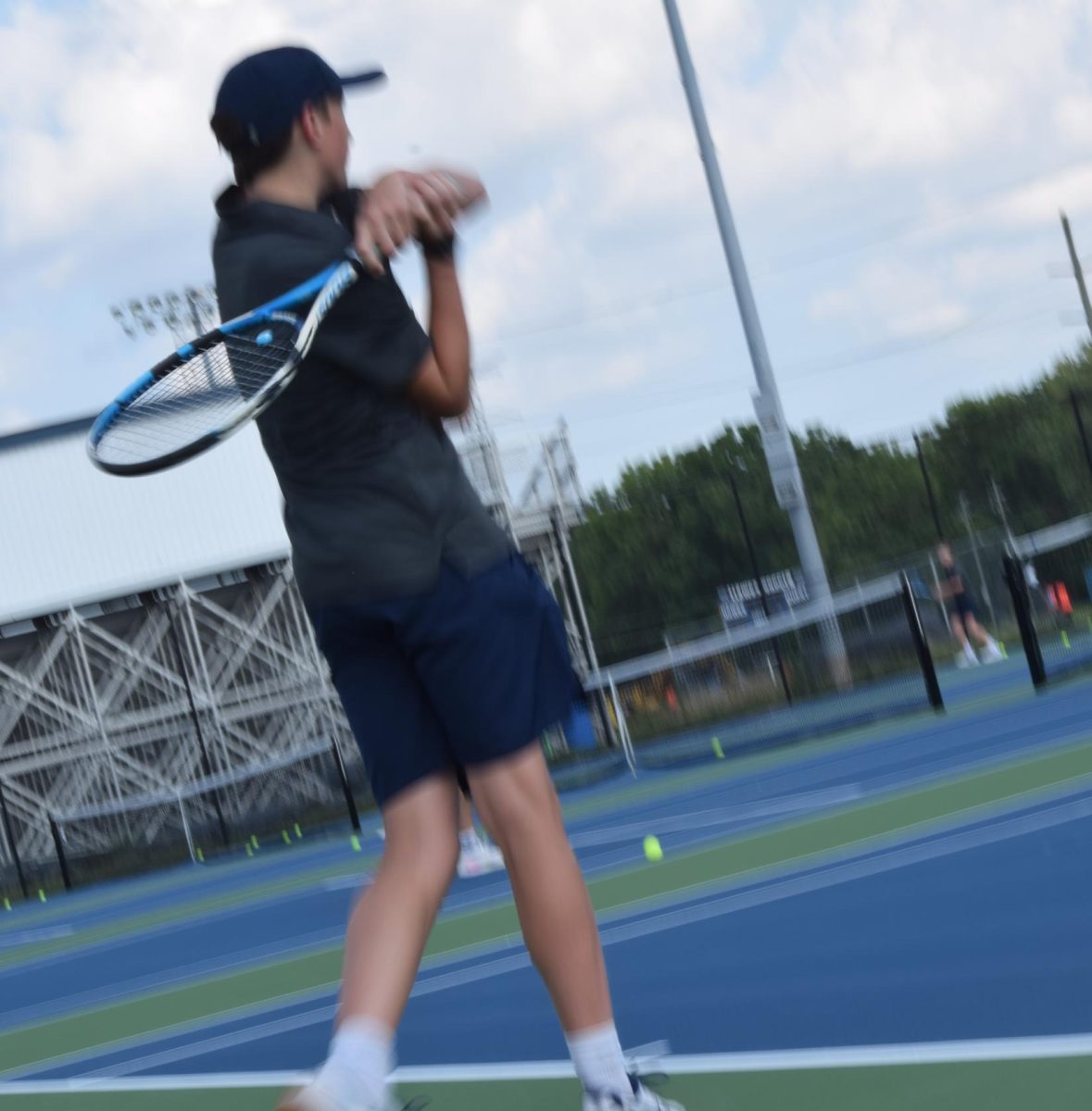 Junior Benjamin Koon practices a splice serve. This was doing the practice before the scrimmage at Decatur. "[I] tried my best and had fun", Koon said.