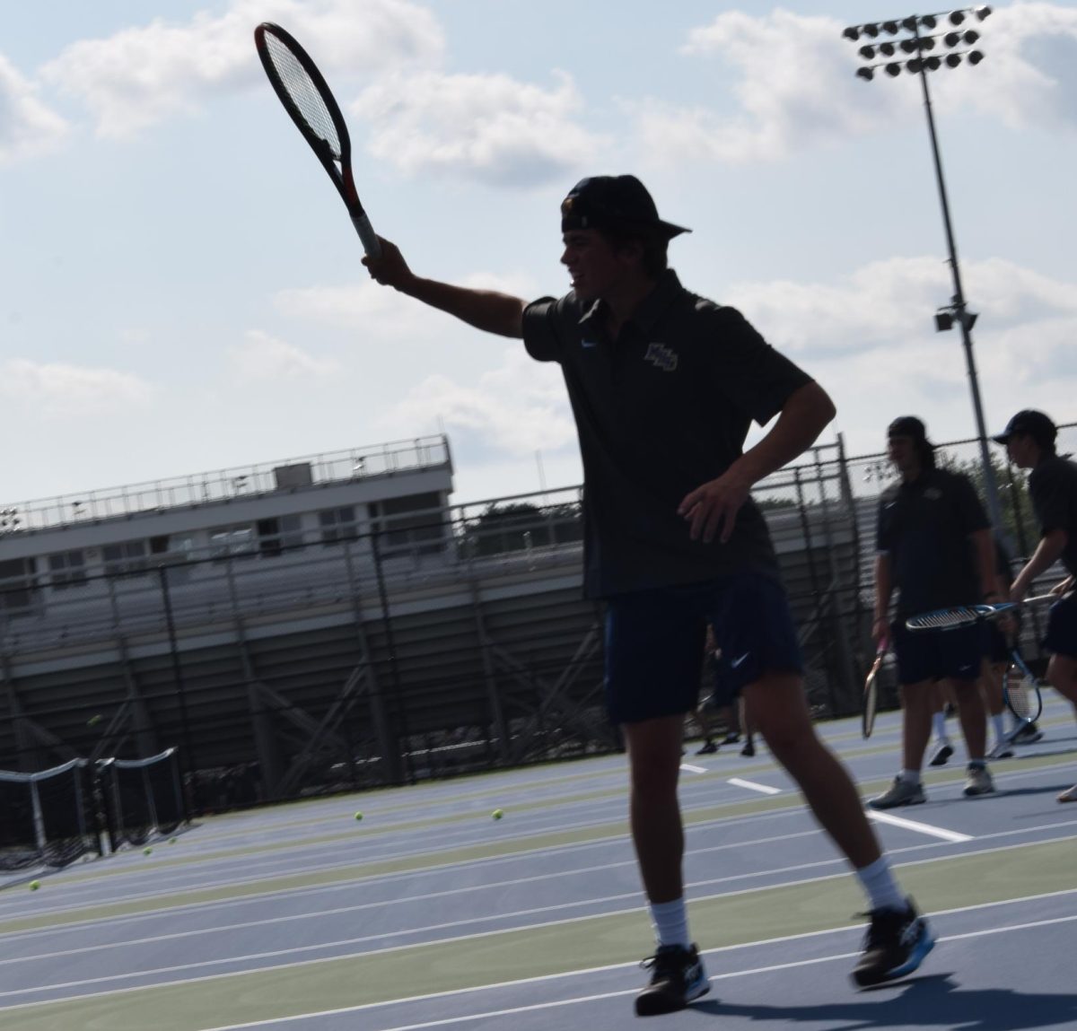 Senior Craig Tieke is following through with a serve. This was the 30 minute practice before the scrimmage at Decatur. 