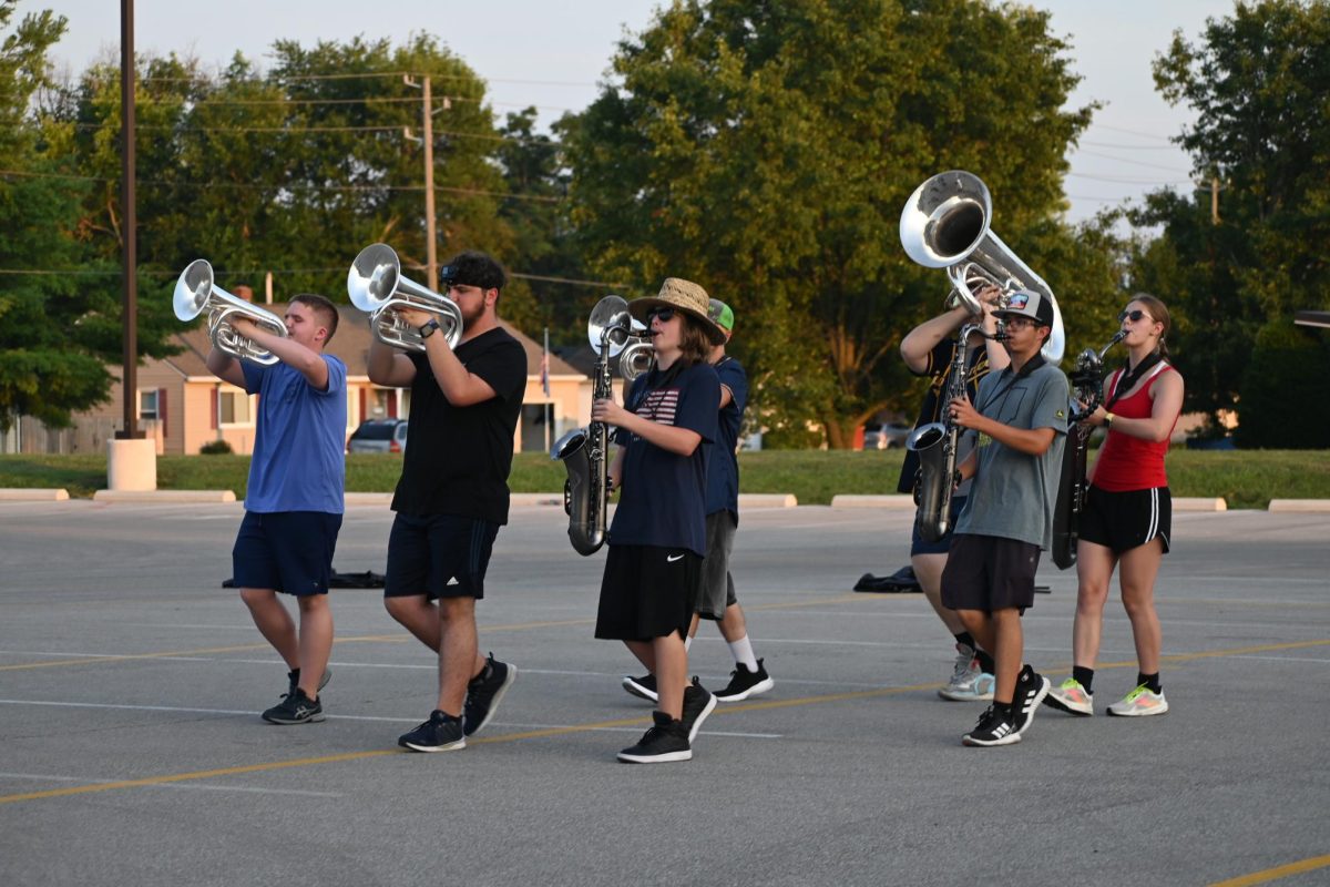 Junior Marissa Lewis marches with a group. Lewis previously played tenor saxophone, but switched over to baritone saxophone her junior year. You get to learn from [other regiment members], but also get to teach them things about music, Lewis said.