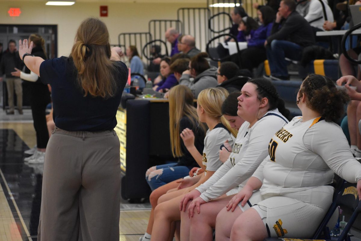 Coach Armstrong is talking to Teagan Gray, Maddison Boyd, Madi Philips, and Miia Williams. They just came back from playing as Armstrong is coaching them while they wait to get back on. My coach has inspired me to out play the people who angered me during the games instead of it getting to me, Gray said. 