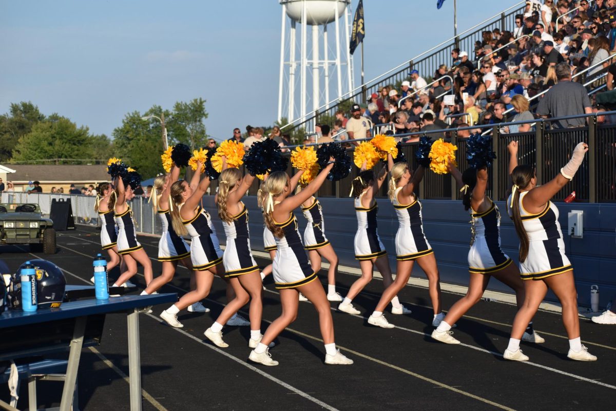  Senior Liz Huffman hits a high V during a cheer. Alongside her teammates supporting Mooresville.  Huffman was chose a co-captain this year. "We had tons of spirit, and our coach was so proud of us. Since it's my senior year I want to make the best out of it. As captain I'm glad I can be someone to look up to," Huffman said. 