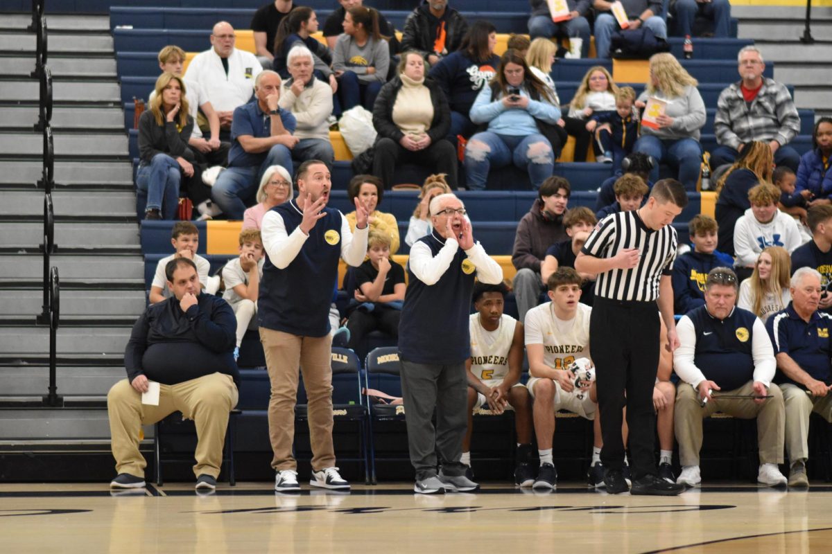 Coaches support their players from the sidelines.