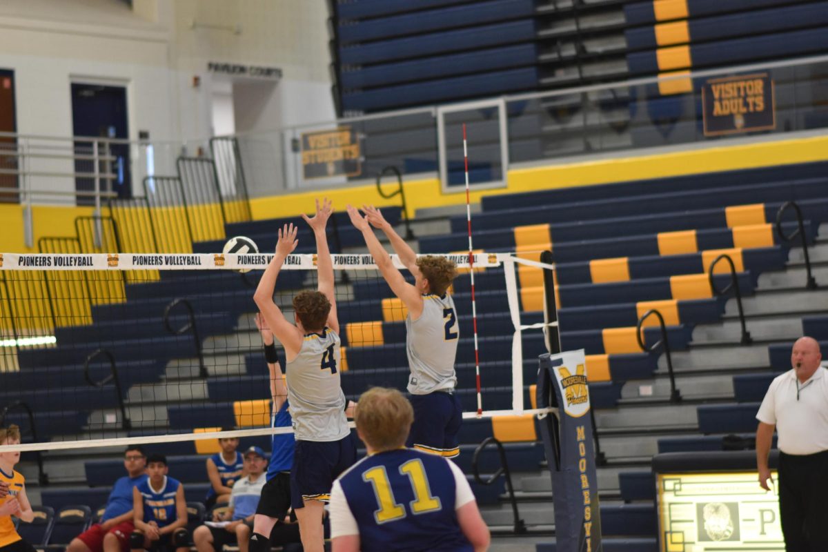 Senior Seth Connor and junior Bryce Bodell jump up to block the ball. 