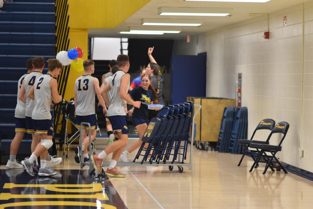 Exchange student Roberta DeRenzis runs off the court with the team after the game. The team has a special tradition of having cookies after every game, provided by Coach Cory's mom. "I wanted to be the manager so I could keep playing volleyball and I wanted to show more school spirit" De Renzis said.