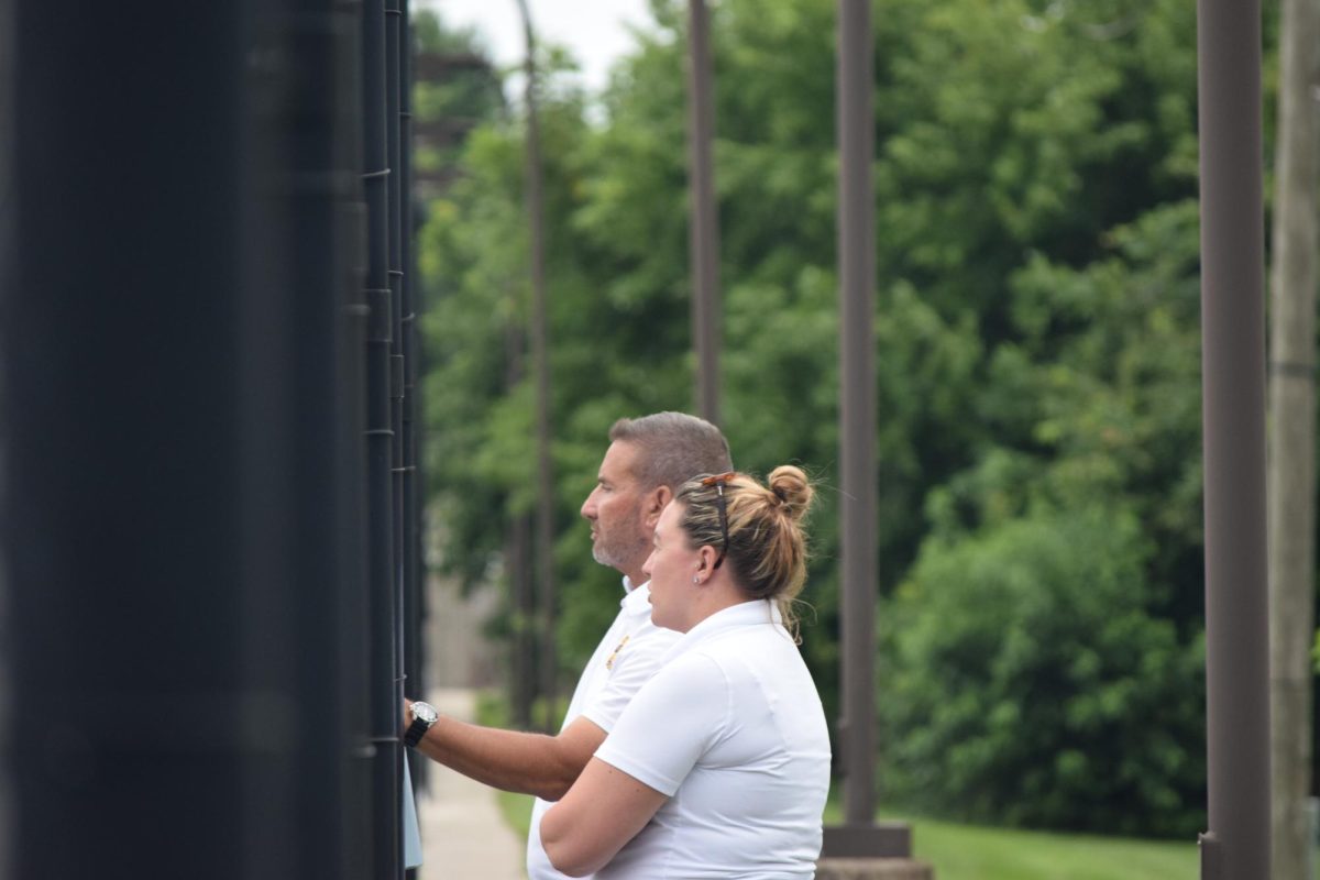 Coaches Danielle Banks and Mike Teders watch the boys as they play tennis. They discuss how the boys are playing and how they can help them. "Sometimes we discuss different strategies for each player to try and practice," Banks said.