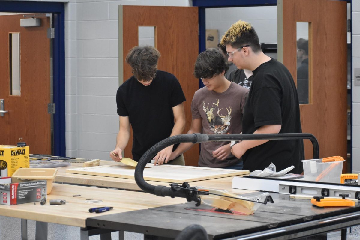 Student Jayden Baker and classmates sand boards for a smoother finish. With the new technology in the building, doing this simple task is easier than ever before. “[The] extra room has helped a lot. Everyone being together has helped collaborate ideas,” Baker said.