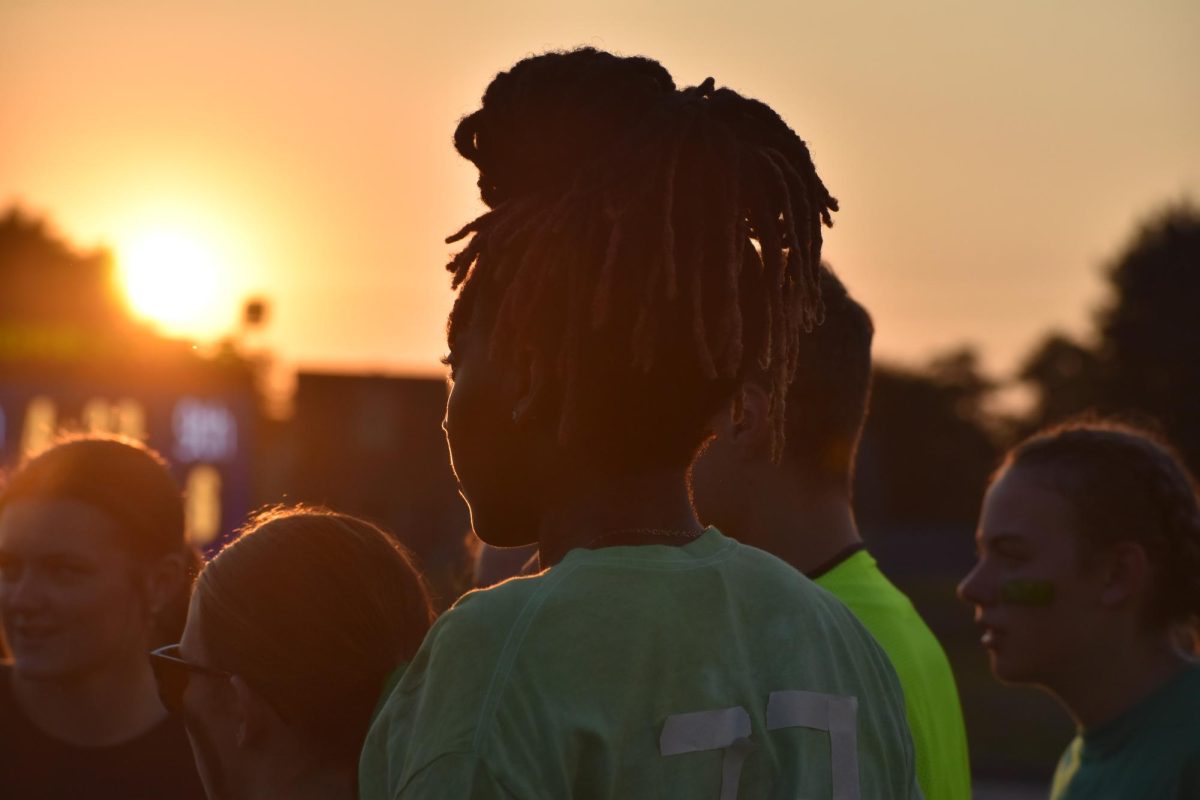 The sun sets over the Homecoming Powderpuff game as the juniors discuss how to finish the game strong.