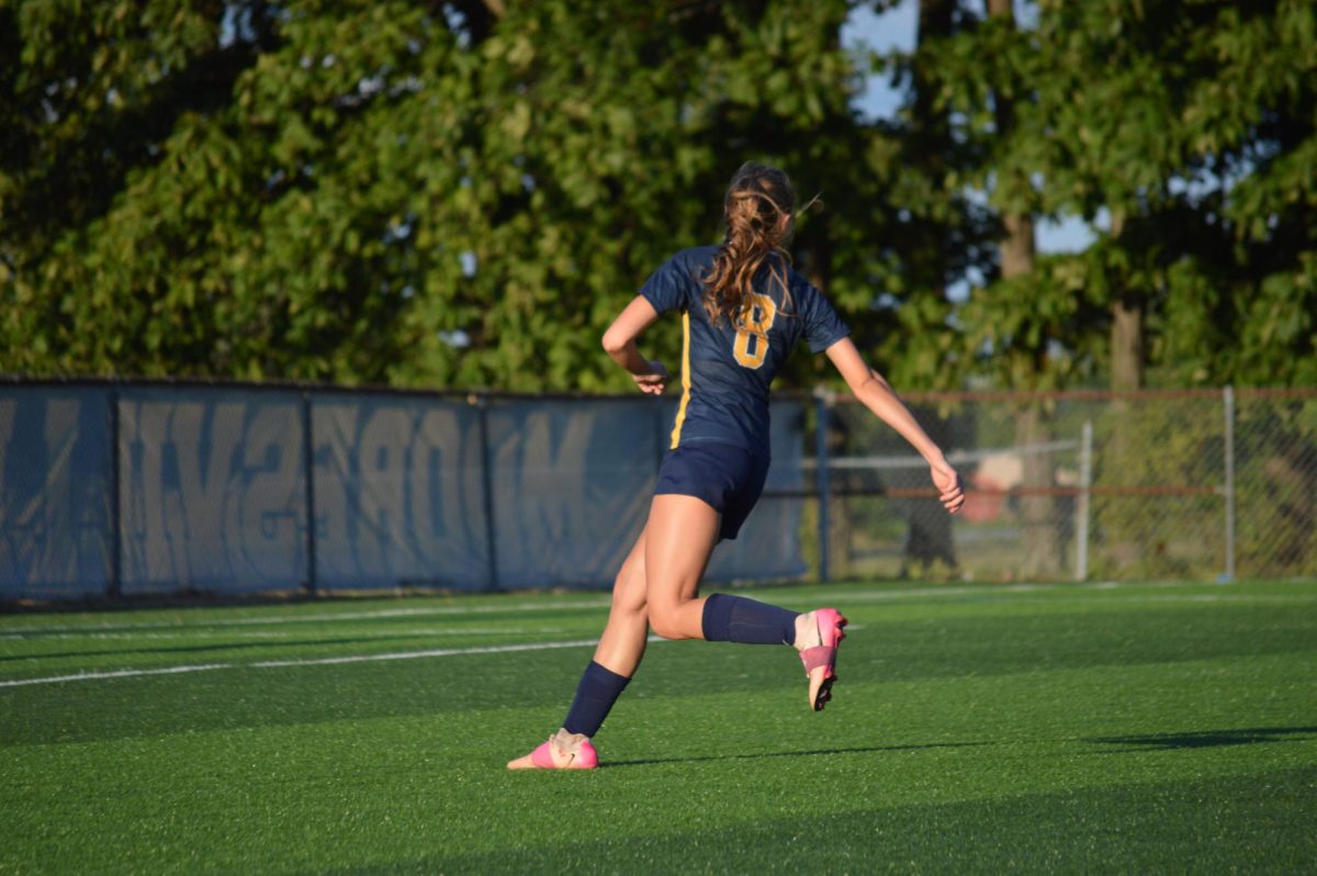 Senior Tayla Savka hustles to receive the ball in their game against the Braves.