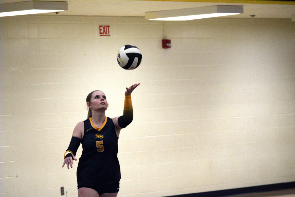 Sophomore Mackenzie Holtzclaw throws the ball and prepares to serve. Holtzclaw had played since seventh grade, and she sees herself still playing in the future. “I see volleyball as teamwork, building friendships, and being competitive,” Holtzclaw said.