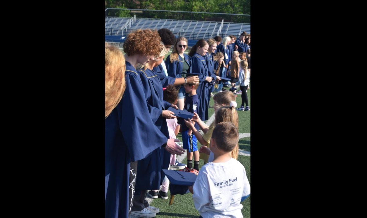 Seniors pass on their caps to kindergarteners during the graduation walk at Northwood.